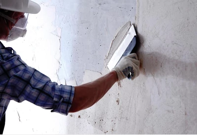 Stucco repair in progress with a trowel and patching material